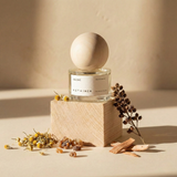 Perfume bottle with wooden cap on a beige background
