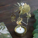 Decorative gold windmill with swan designs on a candle